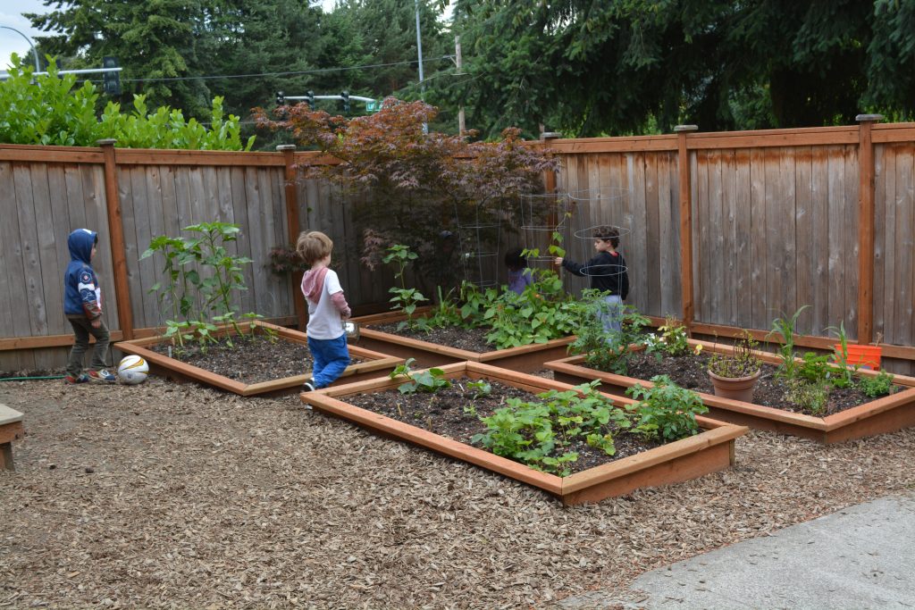 Three children outdoors in Eyas Montessori garden