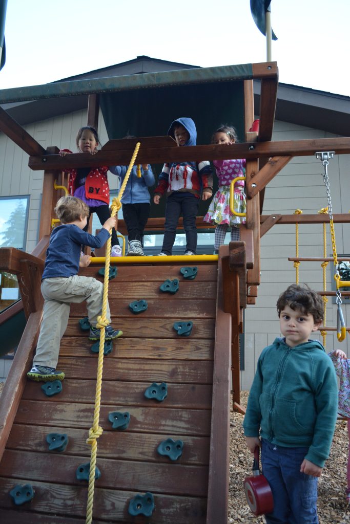 Six children playing on jungle gym at Eyas Montessori playground