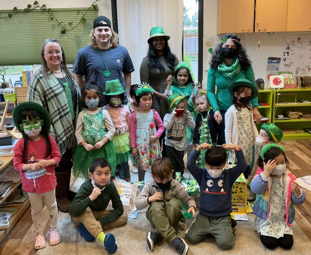 Group of teachers and children in classroom during St. Patrick's day event at Eyas Montessori